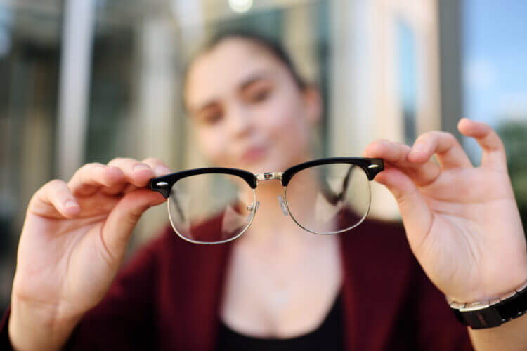 Girl holding glasses close-up