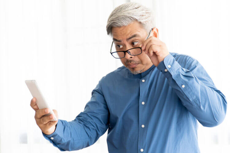 Man with farsightedness looking at phone